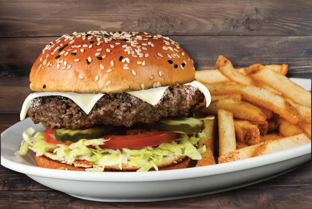 a classic cheeseburger with shredded lettuce and a side of fries